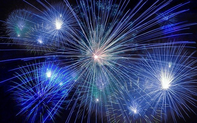 Fuegos artificiales azules explotando en un cielo nocturno