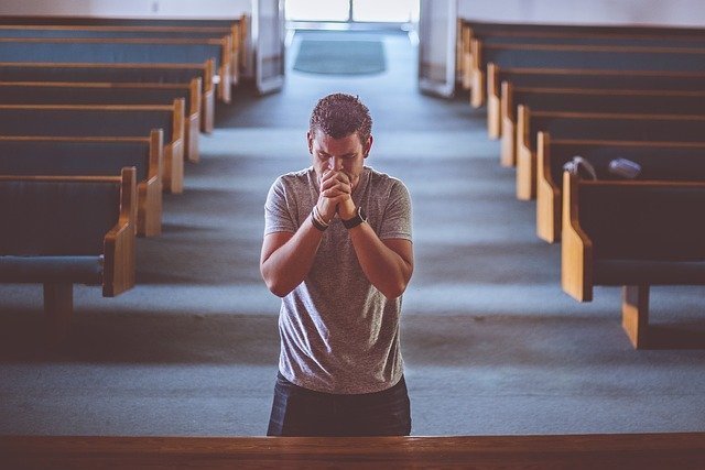no-se-puede-no-ser-espiritual Hombre rezando con unos bancos de iglesia de fondo