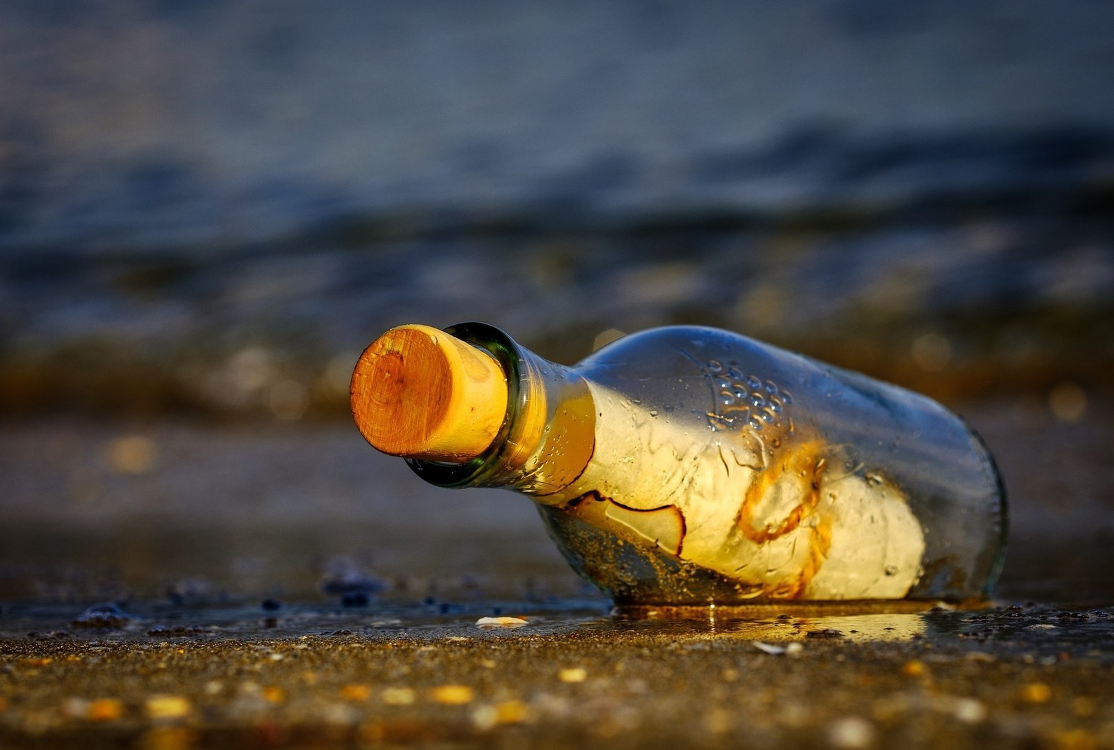 Botella de cristal con mensaje frente al mar
